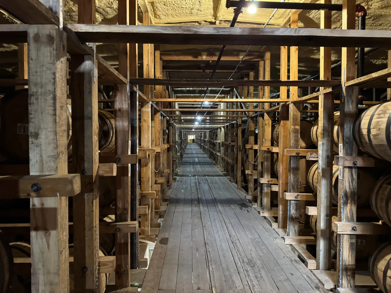 A long timber-lined aisle between barrels in a Buffalo Trace rickhouse.