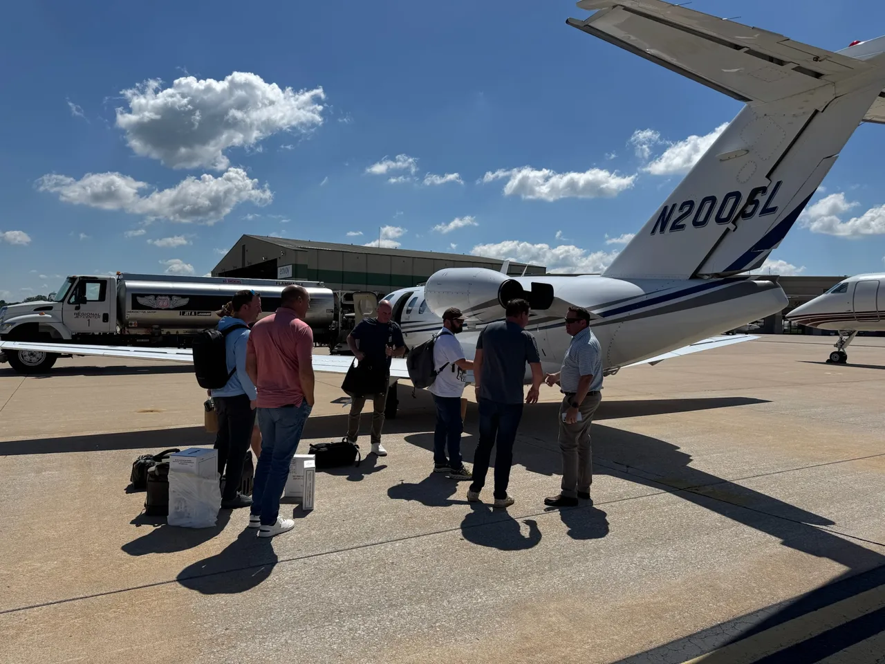 Members arriving together beside an aircraft before a selection trip.